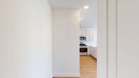 This well-designed 2-bedroom, 2-bathroom residence at 700 Darley Green Dr in Claymont, Delaware, offers a bright and contemporary living experience on a single floor. The open-concept kitchen and living area serves as the heart of the home, where crisp white shaker cabinets, a classic subway tile backsplash, quartz countertops, and a peninsula island create a clean, functional space. Stainless steel appliances, including a gas range, microwave, and refrigerator, complete the modern kitchen. Warm wood-tone luxury flooring flows seamlessly throughout the living areas and bedrooms, complementing the neutral white walls and creating a cohesive, inviting atmosphere. The spacious primary bedroom features large windows that invite abundant natural light and outdoor views, along with a sliding glass door leading to a private balcony. The second bedroom is equally well-lit, with generous proportions and the same warm flooring. Both bathrooms are finished with white subway tile — one featuring a tub-shower combination and the other a walk-in shower — maintaining a clean, consistent aesthetic. A hallway and closet provide practical storage solutions. The overall design is clean, modern, and move-in ready.