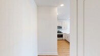 This well-designed 2-bedroom, 2-bathroom residence at 700 Darley Green Dr in Claymont, Delaware, offers a bright and contemporary living experience on a single floor. The open-concept kitchen and living area serves as the heart of the home, where crisp white shaker cabinets, a classic subway tile backsplash, quartz countertops, and a peninsula island create a clean, functional space. Stainless steel appliances, including a gas range, microwave, and refrigerator, complete the modern kitchen. Warm wood-tone luxury flooring flows seamlessly throughout the living areas and bedrooms, complementing the neutral white walls and creating a cohesive, inviting atmosphere. The spacious primary bedroom features large windows that invite abundant natural light and outdoor views, along with a sliding glass door leading to a private balcony. The second bedroom is equally well-lit, with generous proportions and the same warm flooring. Both bathrooms are finished with white subway tile — one featuring a tub-shower combination and the other a walk-in shower — maintaining a clean, consistent aesthetic. A hallway and closet provide practical storage solutions. The overall design is clean, modern, and move-in ready.
