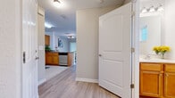 Located in Palm Coast, Florida, this two-story, 3-bedroom, 2-bathroom home is thoughtfully laid out across two floors. The main level offers an open, welcoming flow beginning with light-filled hallways finished with smooth hardwood-style flooring. The kitchen features warm honey-toned cabinetry, granite-look countertops, stainless steel appliances, and tile flooring, seamlessly connecting to a dedicated dining area bathed in natural light through vertical blinds. The adjacent living room impresses with vaulted ceilings, large windows, and the same durable hardwood-style flooring, creating an airy and comfortable gathering space. A full bathroom on the main floor includes a tiled tub/shower combination. Upstairs, three carpeted bedrooms provide comfortable retreats, including a spacious primary bedroom featuring vaulted ceilings, dual windows with outdoor views, a walk-in closet, and plush carpeting. Additional bedrooms are bright and well-sized, each with ample natural light. Throughout the home, neutral wall tones, consistent finishes, and clean architectural lines establish a cohesive, move-in-ready aesthetic well-suited to Florida living.