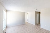 Located on Jefferson Highway in Baton Rouge, Louisiana, this 2-bedroom, 1-bathroom unit offers a practical and clean layout across a single floor. Light-toned luxury vinyl plank flooring runs throughout the space, complemented by neutral-toned walls and textured ceilings, creating a bright and cohesive atmosphere.

The open living area provides a generous amount of room and receives natural light through a large window with blinds, offering views of the surrounding landscape. The galley-style kitchen is efficiently designed with gray cabinetry, laminate countertops, a double stainless steel sink, and black appliances including a refrigerator and range. A window above the sink allows additional natural light into the kitchen.

The spacious primary bedroom features a ceiling fan with light fixture and direct access to a walk-in closet equipped with wire shelving. The second bedroom is a comfortable size with its own window for natural light. A hallway connects the bedrooms to the full bathroom, which includes a single vanity with a mirror, a toilet, and a tub-shower combination. A dedicated walk-in closet with wire shelving systems provides ample storage. The dining area is conveniently positioned adjacent to the kitchen, completing this functional and move-in-ready layout.