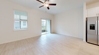Located at 17224 Auburn Arch Loop in Wimauma, FL, this two-story home offers 2 bedrooms and 3 bathrooms thoughtfully laid out across two well-proportioned floors. The main level houses the kitchen and living room, a convenient half bathroom, and an attached garage with an automatic opener. The kitchen is outfitted with white shaker-style cabinetry, white quartz countertops, a classic subway tile backsplash, and stainless steel appliances, including a range, microwave, and dishwasher. Light wood-look tile flooring flows throughout the main living areas, contributing to a bright, airy feel. The living room features elevated ceilings, a ceiling fan, and sliding glass doors that open to a private balcony, allowing natural light to fill the space. Upstairs, the generously sized primary bedroom includes a tray ceiling with ceiling fan, plush carpet flooring, dual windows with views of the surrounding neighborhood, and a dedicated en-suite bathroom complete with a walk-in glass shower clad in large-format white tile and a vanity with white cabinetry. A spacious walk-in closet with wire shelving provides ample storage. The second bedroom is also well-sized with its own access to a full bathroom. A dedicated laundry area with a full-size washer and dryer completes the upper floor.