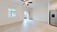 Located at 17224 Auburn Arch Loop in Wimauma, FL, this two-story home offers 2 bedrooms and 3 bathrooms thoughtfully laid out across two well-proportioned floors. The main level houses the kitchen and living room, a convenient half bathroom, and an attached garage with an automatic opener. The kitchen is outfitted with white shaker-style cabinetry, white quartz countertops, a classic subway tile backsplash, and stainless steel appliances, including a range, microwave, and dishwasher. Light wood-look tile flooring flows throughout the main living areas, contributing to a bright, airy feel. The living room features elevated ceilings, a ceiling fan, and sliding glass doors that open to a private balcony, allowing natural light to fill the space. Upstairs, the generously sized primary bedroom includes a tray ceiling with ceiling fan, plush carpet flooring, dual windows with views of the surrounding neighborhood, and a dedicated en-suite bathroom complete with a walk-in glass shower clad in large-format white tile and a vanity with white cabinetry. A spacious walk-in closet with wire shelving provides ample storage. The second bedroom is also well-sized with its own access to a full bathroom. A dedicated laundry area with a full-size washer and dryer completes the upper floor.