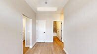 This single-floor residence offers a thoughtfully designed layout across a generous footprint, combining functionality with contemporary finishes. The open-concept kitchen serves as a central highlight, featuring rich dark-stained cabinetry, stainless steel appliances, a patterned geometric tile backsplash, and a large white quartz island beneath three pendant lights. Light wood-look flooring flows throughout the main living and common areas, complementing the neutral gray wall tones and bright white trim.

The living room benefits from multiple windows that invite natural light and outdoor views, enhanced by a tray ceiling that adds architectural depth. Both bedrooms are carpeted and feature tray ceilings, double-pane windows with blinds, and ample closet space, including double doors in the second bedroom. The primary bedroom offers a comfortable, well-proportioned retreat.

The bathroom features wood-look tile flooring, a quartz-topped vanity, dark matte hardware, and a full tub-shower combination with large-format wall tile. The dedicated laundry room includes a side-by-side washer and dryer, utility sink, and dark wood upper cabinetry. Three hallways connect the private and shared spaces efficiently, contributing to a clean, organized floor plan.
