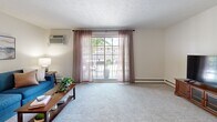 Located at 13911 Oakbrook Dr in North Royalton, Ohio, this two-bedroom, one-bathroom residence offers a well-organized single-floor layout across a comfortable footprint. The living room is bright and open, featuring plush carpeting, a textured ceiling, and a large sliding glass door that floods the space with natural light and provides access to a private balcony with outdoor views. An entry foyer with hardwood-style flooring transitions seamlessly into the carpeted living areas. The dining room is a defined space enhanced by a ceiling fan with light fixture, neutral walls, and room for a full dining set. The galley-style kitchen is well-equipped with warm wood cabinetry, ample counter space, a full suite of appliances, and light hardwood-style flooring that adds warmth to the room. The primary bedroom is generously sized with a large window, carpet flooring, and a sliding-door closet offering practical storage. The second bedroom also features natural light from a window and built-in closet access. The full bathroom includes a tiled tub-shower combination, a single-sink vanity with white cabinetry, and tile flooring. A hallway connects the bedrooms and bathroom, completing this efficiently designed home.