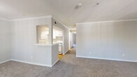 Located at 4601 E Nasa Pkwy in Pasadena, TX, this single-floor, three-bedroom, four-bathroom home offers a functional and well-appointed layout. The open living room greets you at the entry, featuring crown molding, neutral carpet, and a large window that fills the space with natural light and outdoor views. A pass-through opening connects the living area to the galley-style kitchen, which is equipped with white cabinetry, white appliances including a gas range and refrigerator, a dishwasher, and hardwood flooring — providing an efficient and clean workspace. A hallway leads to the three bedrooms, each carpeted and outfitted with ceiling fans and windows for natural light. The primary bedroom includes a walk-in closet with wire shelving for organized storage. The four bathrooms feature a mix of tub/shower combos with clean white surrounds, with some bathrooms showcasing hardwood flooring, white vanity cabinetry, and large mirrors. A dedicated in-unit laundry closet houses a full-size side-by-side washer and dryer. Throughout the home, consistent white trim, crown molding in key areas, and a neutral color palette create a cohesive, move-in-ready atmosphere.