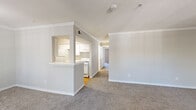 Located at 4601 E Nasa Pkwy in Pasadena, TX, this single-floor, three-bedroom, four-bathroom home offers a functional and well-appointed layout. The open living room greets you at the entry, featuring crown molding, neutral carpet, and a large window that fills the space with natural light and outdoor views. A pass-through opening connects the living area to the galley-style kitchen, which is equipped with white cabinetry, white appliances including a gas range and refrigerator, a dishwasher, and hardwood flooring — providing an efficient and clean workspace. A hallway leads to the three bedrooms, each carpeted and outfitted with ceiling fans and windows for natural light. The primary bedroom includes a walk-in closet with wire shelving for organized storage. The four bathrooms feature a mix of tub/shower combos with clean white surrounds, with some bathrooms showcasing hardwood flooring, white vanity cabinetry, and large mirrors. A dedicated in-unit laundry closet houses a full-size side-by-side washer and dryer. Throughout the home, consistent white trim, crown molding in key areas, and a neutral color palette create a cohesive, move-in-ready atmosphere.