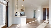 Located at 1450 Lakefront Dr in Sarasota, Florida, this single-floor residence showcases a clean, modern aesthetic defined by crisp white walls, light wood-look flooring, and bold matte black hardware and door accents throughout. The open-concept kitchen is a standout feature, equipped with stainless steel appliances including a refrigerator, range, and over-the-range microwave, complemented by white cabinetry, light quartz countertops, a built-in wine rack, and stylish pendant lighting above the peninsula island. Natural light pours through large windows, with select rooms offering picturesque views of the surrounding lakefront scenery. The bathrooms are finished with elegant marble-look tile flooring, white vanities with matte black fixtures, and a glass-enclosed shower, lending a spa-like quality. Bedrooms are bright and airy, featuring walk-in closets with wire shelving systems for ample storage. A dedicated laundry room houses a full-size washer and dryer. Wide hallways connect each space seamlessly, enhancing the home's open and flowing layout. Every detail reflects a contemporary design sensibility, making this Sarasota residence a refined and functional living environment.
