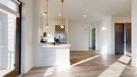 Located at 1450 Lakefront Dr in Sarasota, Florida, this single-floor residence showcases a clean, modern aesthetic defined by crisp white walls, light wood-look flooring, and bold matte black hardware and door accents throughout. The open-concept kitchen is a standout feature, equipped with stainless steel appliances including a refrigerator, range, and over-the-range microwave, complemented by white cabinetry, light quartz countertops, a built-in wine rack, and stylish pendant lighting above the peninsula island. Natural light pours through large windows, with select rooms offering picturesque views of the surrounding lakefront scenery. The bathrooms are finished with elegant marble-look tile flooring, white vanities with matte black fixtures, and a glass-enclosed shower, lending a spa-like quality. Bedrooms are bright and airy, featuring walk-in closets with wire shelving systems for ample storage. A dedicated laundry room houses a full-size washer and dryer. Wide hallways connect each space seamlessly, enhancing the home's open and flowing layout. Every detail reflects a contemporary design sensibility, making this Sarasota residence a refined and functional living environment.