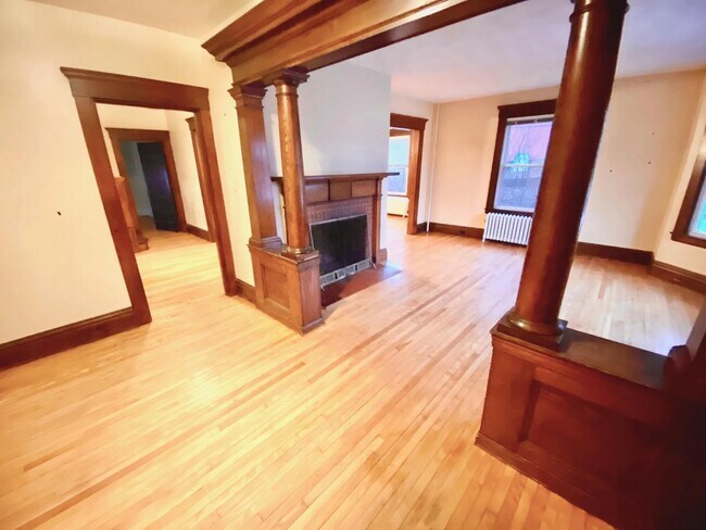 front Foyer overlooking living room and exposed brick fireplace - 824 Pleasant St
