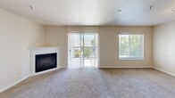 Located at 1425 McNeil St in DuPont, WA, this 2-bedroom, 2-bathroom single-floor residence offers a thoughtfully designed layout with a warm, neutral palette throughout. The living room serves as the heart of the home, highlighted by a corner fireplace with a white mantel, plush carpeting, and sliding glass doors that open to a private balcony, allowing natural light to fill the space. An additional window further brightens the area with views of the surrounding greenery.

The open-concept design seamlessly connects the living room to the dining area and kitchen. The kitchen features warm wood cabinetry, generous counter space, a double sink, and hardwood-style flooring, with full appliances including a refrigerator, range, and dishwasher.

The spacious primary bedroom offers comfortable carpeting, a closet, and a bright window with outdoor views. The second bedroom is equally well-sized with natural light and carpet. Both bathrooms are cleanly finished — one with a tub/shower combo and another with a wood-toned vanity, large mirror, and grey countertop.

Additional highlights include a dedicated in-unit laundry room with full-size washer and dryer hookups, four closets providing ample storage, and a practical, move-in-ready layout ideal for comfortable everyday living.