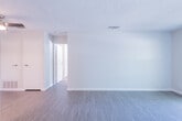This single-floor residential unit offers a practical and well-organized layout designed for comfortable everyday living. The main living area is bright and open, finished with durable wood-style flooring that extends throughout the primary spaces. A ceiling fan adds functionality to the room, while a sliding glass door floods the space with natural light and provides direct access to a private balcony overlooking lush greenery — a welcoming outdoor retreat.

The kitchen is efficiently designed with white cabinetry, light countertops, and stainless steel appliances including a refrigerator and electric range, complemented by light wood-style flooring that ties seamlessly into the overall aesthetic.

The bedroom offers a quieter, carpeted environment with a window that allows natural light to filter in, creating a comfortable and restful atmosphere. Closet access within the bedroom adds to the unit's practical storage options.

The bathroom is cleanly appointed with a single-sink vanity featuring a gray countertop, a large mirror with medicine cabinet, and a full tub-shower combination with chrome fixtures. Textured ceilings are consistent throughout the unit, adding a classic residential character. Overall, the space presents a clean, move-in ready environment with a neutral palette that provides a versatile backdrop for personalization.