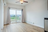 Located on Central Park Place in Fitchburg, WI, this one-bedroom, one-bathroom unit offers a thoughtfully designed single-floor layout that maximizes comfort and functionality. Light-toned hardwood-style flooring flows throughout the main living areas, creating a bright and cohesive aesthetic. The open-concept kitchen and living area is a standout feature, showcasing rich dark-brown cabinetry extending to the upper walls, white quartz-style countertops, and a full suite of stainless steel appliances including a refrigerator, range, microwave, and dishwasher. A ceiling fan overhead and a sliding glass door leading to a private patio fill the living space with natural light and outdoor access. The bedroom is carpeted for warmth and comfort, features its own ceiling fan, a window with natural light, a built-in closet, and a wall-mounted HVAC unit for climate control. The bathroom continues the consistent design language with dark cabinetry, a white countertop vanity, and hardwood-style flooring. A dedicated laundry area includes a stacked washer and dryer unit alongside wire shelving for additional storage. This unit combines modern finishes with practical amenities throughout.
