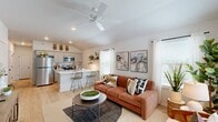 Located at 1800 NW 115th Terr in Oklahoma City, OK, this well-designed 2-bedroom, 2-bathroom home offers a thoughtful single-story layout with stylish finishes throughout. The open-concept living and kitchen area is anchored by soaring vaulted ceilings and a ceiling fan, creating an airy, spacious feel. Large windows flood the space with natural light, while light wood-style flooring runs seamlessly through the main areas, enhancing the home's warm and cohesive aesthetic.

The kitchen is a functional centerpiece, featuring gray shaker-style cabinetry, white quartz countertops, a stainless steel appliance suite including a refrigerator, microwave, and range, a subway tile backsplash, and a peninsula with bar seating — ideal for casual dining or entertaining.

Both bedrooms offer vaulted ceilings, ceiling fans, and windows with natural light. The primary bedroom is a comfortable retreat with its own closet. Each bathroom is finished with gray cabinetry, white countertops, light wood-style flooring, and a tub/shower combination adorned with large-format marble-look tile surrounds, lending a clean and modern feel.

Two closets provide ample storage, and the overall design strikes a balance between contemporary style and everyday practicality.
