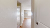 Located at 680 E Jefferson Ave in Englewood, Colorado, this one-bedroom, one-bathroom unit offers an efficiently arranged single-floor layout. The living room features light-toned hardwood-style flooring that reflects natural sunlight streaming through a large window dressed with vertical blinds, creating a bright and open atmosphere. A wall-mounted air conditioning unit and baseboard heating provide year-round climate control. The kitchen is positioned adjacent to the living area and includes stainless steel appliances, with warm wood cabinetry providing practical storage.

The bedroom is carpeted in a neutral beige tone and includes a ceiling fan with a light fixture, a baseboard heater, and a window with vertical blinds that allows natural light to filter in. A set of white bifold closet doors with a classic paneled design provides organized storage space within the bedroom.

The bathroom is finished with full-height ceramic tile surrounding a white soaking tub and shower combination. A decorative mosaic tile border adds visual interest, while brushed nickel fixtures and a warm wood-toned vanity complete the space. Neutral wall tones throughout the unit create a cohesive, understated aesthetic that is both clean and functional.