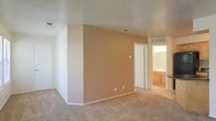 This single-floor residence offers a clean and functional layout designed for comfortable everyday living. The interior is finished with wall-to-wall carpeting throughout, providing a soft and warm underfoot feel that complements the neutral, earthy tones of the walls. The main living area is open and uncluttered, featuring a textured ceiling and standard overhead ventilation, giving the space a practical and well-maintained character. Warm beige accent walls add a touch of color and visual depth without overwhelming the overall palette.

A doorway leads directly to a connected bathroom, which is equipped with warm wood-toned cabinetry, a vanity sink, and a well-lit mirror framed by overhead lighting — creating a functional and inviting grooming space. A closet door adjacent to the bathroom entry provides convenient storage access within the same area.

The layout flows naturally between spaces, with consistent flooring and finishes tying the rooms together cohesively. The overall ambiance is calm and neutral, making it a versatile space well-suited for personalization. With its straightforward design and practical features, this residence provides a solid foundation for comfortable single-level living.