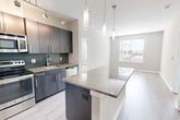 Located at 3400 Columbia Pike in Arlington, VA, Unit 514 is a well-appointed 2-bedroom, 2-bathroom residence offering a thoughtfully designed open-concept floor plan across a single level. The kitchen is a standout feature, showcasing dark espresso cabinetry, a mosaic tile backsplash, granite countertops, and a full suite of stainless steel appliances including a refrigerator, range, microwave, and dishwasher. A large granite-topped island with pendant lighting serves as the centerpiece, seamlessly connecting the kitchen to the combined dining and living area. Light wood-style flooring runs throughout the main living spaces, enhancing the bright, modern aesthetic. The living room benefits from a large window that brings in natural light and outdoor views. Both bedrooms are comfortably sized, carpeted for warmth, and feature windows with exterior views. The primary bedroom is notably spacious and includes generous closet space. The bathrooms are finished with clean white tile, including a soaking tub with a classic black accent tile border. Additional conveniences include three closets and an in-unit laundry room, rounding out this efficiently designed urban residence.