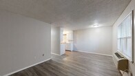 Located at 924 Quincy St in Fort Smith, Arkansas, this 2-bedroom, 1-bathroom single-floor unit offers a practical and efficiently arranged layout. The open living area greets you at the entrance, featuring durable wood-look laminate flooring and a textured ceiling throughout. A wall-mounted PTAC unit and a window with blinds provide climate control and natural light to the living space.

The galley-style kitchen is efficiently designed with white upper and lower cabinetry, light countertops, a stainless steel double-basin sink, and black appliances including an electric range and refrigerator. The kitchen opens visually to the main living area, enhancing the sense of openness.

Both bedrooms are equipped with ceiling fans and closets, with the secondary bedroom featuring a closet with built-in shelving and a window that allows natural light to filter in. The primary bedroom includes its own closet and connects conveniently to the rest of the unit.

The bathroom is clean and straightforward, featuring a full-size soaking tub with a shower surround, a toilet, and a vanity. Consistent wood-look flooring runs through the main living areas and bedrooms, tying the space together with a cohesive, neutral aesthetic throughout.