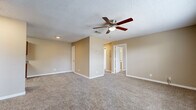 Located at 189 Walmart Ln in Biloxi, Mississippi, this single-story 2-bedroom home offers a functional and comfortable layout designed for everyday living. The combined kitchen and living area serves as the heart of the home, with the galley-style kitchen standing out as a highlight. It features rich, warm-toned wood cabinetry, granite-look countertops, a double sink, and a full suite of stainless steel appliances including a refrigerator, electric range, over-the-range microwave, and dishwasher. Light wood-look flooring runs throughout the kitchen, adding a clean, modern touch. Both bedrooms are carpeted and finished in neutral warm beige tones, each equipped with a ceiling fan with light fixture. The spacious primary bedroom includes direct access to a walk-in closet outfitted with wire shelving systems for organized storage. The second bedroom features a large window that invites natural light and includes its own closet. A dedicated laundry area houses a full-size top-load washer and dryer. Throughout the home, textured ceilings, clean white trim, and consistent neutral wall tones create a cohesive and practical living environment.