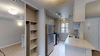 This single-story residence at 43315 16th St W in Lancaster, California, offers a practical and well-organized layout designed for comfortable everyday living. The interior is finished with a neutral color palette throughout, complemented by textured ceilings that add subtle dimension to each room.

The kitchen is a functional galley-style space equipped with stainless steel appliances, including a refrigerator and a gas range. White cabinetry extends to the ceiling, providing generous storage, while a peninsula with a light-toned countertop and an integrated sink serves as a natural divider between the kitchen and adjoining areas. Light wood-look flooring runs through the kitchen, adding warmth and easy maintenance.

The living area is generously proportioned, featuring plush carpeting and a sliding door that opens to an outdoor space, allowing natural light to filter in. The open sightline connecting the living area to the kitchen creates a cohesive, airy feel.

Bedrooms are carpeted and include windows that bring in natural light. One bedroom features a walk-in closet with built-in shelving, offering ample storage. Additional built-in open shelving is found near the kitchen area, providing further organizational options.

The bathroom includes a full-size soaking tub and shower combination with clean white surroundings and brushed nickel hardware accents.