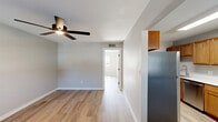 Located at 1764 N Leverett Ave in Fayetteville, Arkansas, this efficient one-bedroom, one-bathroom unit offers a well-designed single-floor layout with a clean, updated aesthetic throughout. Light-toned luxury vinyl plank flooring runs continuously across the living spaces, complementing the neutral gray walls and crisp white trim found in every room.

The living room is bright and welcoming, featuring a ceiling fan and multiple windows that allow natural light to fill the space. A front entry door with sidelights adds to the open, airy feel. The layout flows naturally into the kitchen, which is equipped with warm wood cabinetry, white countertops, a stainless steel refrigerator, gas range, and dishwasher, along with a single-basin sink. A skylight above enhances natural illumination in this functional cooking space.

The bedroom is comfortably sized, offering a ceiling fan, a window with outdoor views, and access to a dedicated closet with built-in hanging rods. Two additional closets elsewhere in the unit provide generous storage. The bathroom includes a wood-toned vanity with white countertop, a framed mirror, and a combined tub and shower. The overall ambiance is clean, understated, and move-in ready.