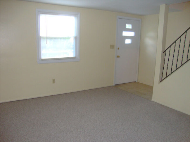 Living room looking toward stairs and door to the deck. - 686 Charlotte Ave
