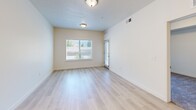 Located at 231 W 12th St in Ogden, Utah, this one-bedroom, one-bathroom residence offers a thoughtfully designed single-floor layout with clean, modern finishes throughout. The open-concept kitchen and living area serves as the heart of the home, where light hardwood-style flooring flows seamlessly underfoot. The kitchen is well-equipped with white shaker cabinetry, white quartz countertops, stainless steel appliances including a refrigerator, range, microwave, and dishwasher, and a peninsula with a built-in sink — ideal for both everyday cooking and casual dining. The living area is bathed in natural light from large windows and a sliding glass door that opens onto a private balcony, offering views of the surrounding greenery. The spacious primary bedroom features plush carpeting, a tray ceiling detail, and its own sliding glass door access to the balcony, creating a bright and airy retreat. The full bathroom presents a clean, all-white design with tile flooring, an extended vanity with ample cabinet storage, and a shower-tub combination. A dedicated laundry area with a full-size washer and dryer adds everyday convenience. The overall ambiance is bright, neutral, and move-in ready.