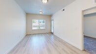 Located at 231 W 12th St in Ogden, Utah, this one-bedroom, one-bathroom residence offers a thoughtfully designed single-floor layout with clean, modern finishes throughout. The open-concept kitchen and living area serves as the heart of the home, where light hardwood-style flooring flows seamlessly underfoot. The kitchen is well-equipped with white shaker cabinetry, white quartz countertops, stainless steel appliances including a refrigerator, range, microwave, and dishwasher, and a peninsula with a built-in sink — ideal for both everyday cooking and casual dining. The living area is bathed in natural light from large windows and a sliding glass door that opens onto a private balcony, offering views of the surrounding greenery. The spacious primary bedroom features plush carpeting, a tray ceiling detail, and its own sliding glass door access to the balcony, creating a bright and airy retreat. The full bathroom presents a clean, all-white design with tile flooring, an extended vanity with ample cabinet storage, and a shower-tub combination. A dedicated laundry area with a full-size washer and dryer adds everyday convenience. The overall ambiance is bright, neutral, and move-in ready.