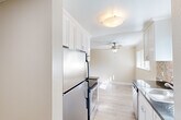 Located at 1212 Whipple Ave in Redwood City, CA, this one-bedroom, one-bathroom residence offers a thoughtfully laid-out single-level floor plan. The living room is a bright, open space featuring light hardwood flooring, crown molding, and a ceiling fan. A large sliding glass door with vertical blinds opens to a private balcony, filling the room with natural light and providing outdoor views. Built-in shelving along one wall adds convenient storage and display space.

The kitchen is efficiently designed with white shaker-style cabinetry extending to the ceiling for ample storage, stainless steel appliances including a refrigerator and range, dark granite-style countertops, and a flush-mount ceiling light.

The bedroom offers plush carpeting, a natural-light window with exterior views, and a mirrored sliding-door closet with built-in shelving for organized storage. Crown molding continues throughout, lending a cohesive, polished feel to the space.

The bathroom features a tub-shower combination with white tile surround, mosaic tile flooring, a dark granite vanity countertop, and clean, bright finishes. Two hallways connect the rooms, contributing to an efficient and functional layout throughout this well-appointed Redwood City residence.