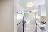 Located at 1212 Whipple Ave in Redwood City, CA, this one-bedroom, one-bathroom residence offers a thoughtfully laid-out single-level floor plan. The living room is a bright, open space featuring light hardwood flooring, crown molding, and a ceiling fan. A large sliding glass door with vertical blinds opens to a private balcony, filling the room with natural light and providing outdoor views. Built-in shelving along one wall adds convenient storage and display space.

The kitchen is efficiently designed with white shaker-style cabinetry extending to the ceiling for ample storage, stainless steel appliances including a refrigerator and range, dark granite-style countertops, and a flush-mount ceiling light.

The bedroom offers plush carpeting, a natural-light window with exterior views, and a mirrored sliding-door closet with built-in shelving for organized storage. Crown molding continues throughout, lending a cohesive, polished feel to the space.

The bathroom features a tub-shower combination with white tile surround, mosaic tile flooring, a dark granite vanity countertop, and clean, bright finishes. Two hallways connect the rooms, contributing to an efficient and functional layout throughout this well-appointed Redwood City residence.