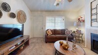 Located at 7201 S 92nd E Ave in Tulsa, Oklahoma, this single-story residence offers a well-organized layout with comfortable, functional living spaces finished in warm, neutral tones throughout. The living room serves as the heart of the home, featuring a tile-surround fireplace as a focal point, a textured ceiling, and a ceiling fan. Natural light filters in through blinded windows, creating a bright and welcoming atmosphere. The space flows seamlessly, offering room for both relaxing and entertaining. The galley-style kitchen is efficiently designed with abundant warm wood cabinetry, white appliances including a range and refrigerator, a stainless steel sink, and durable wood-look flooring. Ample counter and storage space make this kitchen highly practical. The residence includes two bedrooms, both carpeted and finished with soft, neutral walls and textured ceilings. Each bedroom benefits from windows that allow natural light to brighten the space, providing a calm and restful environment. The bathroom features wood-look flooring, a vanity with an integrated sink, overhead cabinetry with louvered doors, and a clean, understated design. Throughout the home, consistent use of neutral palettes and warm materials contributes to a cohesive and comfortable living experience.