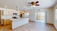 Located at 3277 Birch St in Eau Claire, Wisconsin, this single-floor residence offers three bedrooms and four bathrooms within a well-designed, functional layout. The open-concept kitchen and living area serves as the heart of the home, featuring light maple cabinetry, a generous island with a white quartz countertop and undermount sink, pendant lighting, and a full suite of stainless steel appliances including a refrigerator, range, and microwave. Light hardwood-style flooring flows throughout the entire unit, lending a cohesive and airy feel. The living area is bright and welcoming, enhanced by a ceiling fan and a large sliding glass door that opens to a private balcony with outdoor views. Additional windows throughout the space invite abundant natural light. The bedrooms are comfortably sized, each equipped with a ceiling fan and windows overlooking the surrounding neighborhood. The primary bedroom offers generous proportions. The four bathrooms feature clean, modern walk-in shower stalls, light wood vanities, and matching flooring. A hallway with warm wood-trimmed doorways connects the bedroom wing, completing the practical and thoughtfully designed floor plan of this Eau Claire residence.