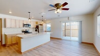 Located at 3277 Birch St in Eau Claire, Wisconsin, this single-floor residence offers three bedrooms and four bathrooms within a well-designed, functional layout. The open-concept kitchen and living area serves as the heart of the home, featuring light maple cabinetry, a generous island with a white quartz countertop and undermount sink, pendant lighting, and a full suite of stainless steel appliances including a refrigerator, range, and microwave. Light hardwood-style flooring flows throughout the entire unit, lending a cohesive and airy feel. The living area is bright and welcoming, enhanced by a ceiling fan and a large sliding glass door that opens to a private balcony with outdoor views. Additional windows throughout the space invite abundant natural light. The bedrooms are comfortably sized, each equipped with a ceiling fan and windows overlooking the surrounding neighborhood. The primary bedroom offers generous proportions. The four bathrooms feature clean, modern walk-in shower stalls, light wood vanities, and matching flooring. A hallway with warm wood-trimmed doorways connects the bedroom wing, completing the practical and thoughtfully designed floor plan of this Eau Claire residence.