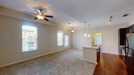 This thoughtfully designed two-bedroom, two-bathroom residence in Spring, Texas offers a comfortable and functional single-floor layout. The open-concept living and dining area is anchored by a tray ceiling with a ceiling fan, creating a defined yet airy atmosphere. Multiple windows flood the space with natural light, while plush wall-to-wall carpeting adds warmth underfoot.

The kitchen is a standout feature, showcasing rich dark espresso cabinetry with sleek hardware, light granite countertops, and a peninsula with an undermount double sink — ideal for both meal prep and casual dining. Pendant lighting above the peninsula adds a stylish touch, and black appliances including an electric range and over-the-range microwave complete the space. Wood-look flooring runs throughout the kitchen, providing a clean contrast to the cabinetry.

Both bedrooms are carpeted and well-lit by large windows with blinds, offering comfortable retreats with ample natural light. The two bathrooms are consistently finished with dark vanity cabinetry, white countertops, large mirrors, wood-look flooring, and tub-shower combinations. A connecting hallway links the living area to the bedrooms and bathrooms, ensuring a practical and cohesive flow throughout the residence.