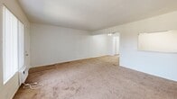 Located at 1130 W Fourth St in Ontario, CA, this one-bedroom, one-bathroom unit offers a practical and well-organized single-floor layout. The combined living, dining, and kitchen area forms the heart of the home, providing an open and connected feel. The living and dining spaces feature wall-to-wall carpet and are brightened by large windows with vertical blinds that allow natural light to filter in. A front entry door opens directly into the living area, which also includes a wall-mounted air conditioning unit for year-round comfort. A pass-through opening connects the living and dining area to the kitchen, which transitions to smooth hardwood-style flooring. The kitchen is equipped with warm honey-toned wood cabinetry, ample upper and lower storage, a double sink, and a full-size refrigerator, all beneath bright overhead lighting. A hallway leads to the spacious bedroom, which features plush carpet, a large window with natural outdoor views, and a full-width sliding closet. An additional closet provides extra storage. The bathroom includes a full tub-and-shower combination with clean white tile surround and a window for ventilation. The overall aesthetic is clean, bright, and functional throughout.