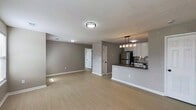 This 810-square-foot, single-floor apartment at 9101 Renner Blvd, Apt 200, Lenexa, KS offers a well-designed 2-bedroom, 2-bathroom layout with two closets. The modern kitchen is a standout feature, showcasing white shaker-style cabinetry with matte black hardware, gray quartz countertops, a subway tile backsplash, and stainless steel appliances including a gas range, microwave, refrigerator, and dishwasher. A peninsula with pendant lighting provides additional counter space and opens to the main living area. Light wood-style flooring flows throughout the unit, complementing the neutral gray walls and crisp white trim. Both bedrooms are bright and well-proportioned, with large windows fitted with white blinds that allow ample natural light. The primary bedroom measures 130 square feet and connects conveniently to the rest of the unit. The two bathrooms are thoughtfully appointed: one features a tub/shower combo with marble-style surround and matte black fixtures, while the other includes a vanity with a round mirror and a lighted fixture above. The overall aesthetic is clean and contemporary, offering a move-in-ready living environment in Lenexa, KS.