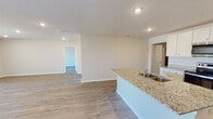 Located on Stonebrooke Drive in Valdosta, Georgia, this single-story home offers a well-designed, open-concept floor plan with a clean, modern aesthetic throughout. Light-toned luxury vinyl plank flooring flows seamlessly through the main living areas, complementing the neutral wall palette and recessed lighting that brightens every room.

The kitchen is a functional centerpiece, equipped with white shaker-style cabinetry, granite countertops, stainless steel appliances including an electric range and over-the-range microwave, and a large island with a double-basin sink that overlooks the open living area. An adjacent pantry provides generous storage. The spacious living room is filled with natural light from multiple windows and a glass-panel back door that opens to the outdoors.

A wide hallway connects the bedrooms, each featuring windows with blinds that allow natural light while maintaining privacy. The primary bathroom includes a double-sink vanity with granite countertops, a soaking tub, a separate walk-in shower, and a window for added brightness. A dedicated walk-in closet with wire shelving provides ample storage.

The home also includes an interior laundry room with a full-size washer and dryer, and an attached two-car garage with an automatic opener and electrical panel access.