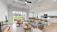 Located at 1100 Oleander Ave in Fort Pierce, FL, this well-appointed single-story, 2-bedroom, 2-bathroom home offers a thoughtfully designed open-concept floor plan. Light wood-look flooring flows seamlessly throughout, complementing the crisp white walls and creating a bright, airy atmosphere.

The welcoming entryway leads into a spacious living area featuring a tray ceiling with a ceiling fan and large sliding glass doors that frame lush outdoor views and flood the space with natural light. The kitchen is a standout, boasting white shaker cabinetry, stainless steel appliances, white quartz countertops, a blue subway tile backsplash, and a generous island with bar seating. The adjacent dining area benefits from a wide window that fills the room with natural sunlight.

The generously sized primary bedroom includes a ceiling fan and access to a walk-in closet, while the second bedroom offers its own window with outdoor views. Both bathrooms are clean and modern; one features a glass-enclosed walk-in shower with mosaic tile flooring and a window for natural ventilation. Two hallways connect the private and communal areas efficiently, enhancing the home's functional flow throughout.