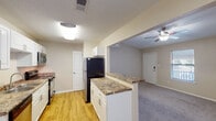 Located in Gulf Breeze, Florida, this single-floor residence offers a thoughtfully designed 2-bedroom, 2-bathroom layout ideal for comfortable everyday living. The open-concept living area features plush carpeting, a ceiling fan with light fixture, and a pass-through connection to the kitchen, creating a bright and cohesive common space. The front entry opens directly into the living area, which benefits from natural light through blinded windows.

The galley-style kitchen is well-appointed with white cabinetry, granite-look countertops, and stainless steel appliances including a range, microwave, dishwasher, and refrigerator. Wood-look flooring runs throughout the kitchen, adding warmth and easy maintenance underfoot.

Both bedrooms are carpeted and feature ceiling fans, windows with blinds, and ample wall space. Each bathroom is equipped with granite-look vanity countertops and white cabinetry. One bathroom includes a tub-shower combo, while the primary bath offers a separate vanity area with a wide mirror and a walk-in shower/tub combination. A textured ceiling finish is consistent throughout the home, complementing the neutral warm-beige color palette that gives the entire residence a clean, move-in-ready feel.