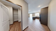 Located in Cold Spring, Minnesota, this single-floor residence offers a thoughtfully designed open-concept layout that seamlessly connects the main living areas. Light-toned luxury vinyl plank flooring flows throughout the common spaces, complemented by neutral wall tones and recessed lighting that create a bright, welcoming atmosphere.

The kitchen is a standout feature, outfitted with rich dark cabinetry, granite-style countertops, and a full suite of stainless steel appliances including a range, microwave, dishwasher, and refrigerator. A central island provides additional prep space and casual seating, while a large window above the sink fills the area with natural light and outdoor views.

The open living area extends generously from the kitchen, offering flexible space for various furniture configurations. Bedrooms are carpeted for comfort, each featuring windows that bring in natural light and views of the surrounding landscape. A spacious walk-in closet with wire shelving systems provides ample storage, and a dedicated utility area is equipped with a wall-mounted washer/dryer unit.

The bathrooms are finished with dark vanity cabinetry and wood-look flooring. One bathroom includes a walk-in shower, while a second offers a full tub and shower combination with brushed nickel fixtures throughout. The overall design balances modern finishes with functional, practical living.