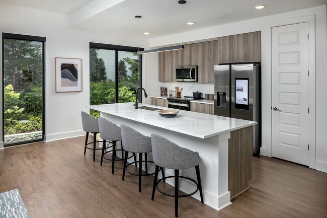 Cocinas gourmet con encimeras y salpicaderos de cuarzo, modernas luminarias y frigoríficos inteligentes de acero inoxidable. - AMLI Atlantic Station