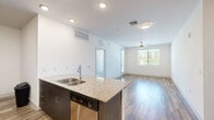 Located at 250 E Ray Rd in Chandler, Arizona, this well-appointed 2-bedroom, 3-bathroom residence offers a thoughtfully designed single-floor layout with a clean, contemporary aesthetic throughout. The open-concept kitchen and living area serves as the heart of the home, featuring warm wood-look flooring, recessed lighting, and a spacious granite-topped island with bar seating. The kitchen is outfitted with dark espresso cabinetry, stainless steel appliances including a refrigerator, range, microwave, and dishwasher, providing both style and functionality. The living area flows seamlessly to a private balcony, allowing for natural light and outdoor access. Both bedrooms are carpeted and include ceiling fans, with the primary bedroom offering a dedicated en-suite bathroom and walk-in closet with built-in shelving and rods. The second bedroom is bright and comfortable, with a window overlooking the exterior. All three bathrooms are finished with granite-topped dark vanities, wood-look tile flooring, and glass-enclosed showers with white tile surrounds. Two generously sized closets add ample storage throughout. The overall ambiance is bright, modern, and move-in ready, with a neutral color palette that complements the contemporary finishes.
