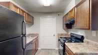 Located at 1788 Austell Rd SW in Marietta, Georgia, this single-story, two-bedroom, one-bathroom residence offers a practical and well-organized layout. The interior is finished with neutral gray walls, white trim, and textured ceilings throughout, creating a clean and consistent aesthetic.

The living area features wood-look luxury vinyl flooring and a large window that brings in natural light and views of surrounding greenery. A hallway connects the main living spaces to the private quarters. The galley-style kitchen is efficiently designed with warm-toned wood cabinetry, granite-look countertops, and black appliances including a gas range, dishwasher, and refrigerator. An adjacent nook provides additional utility space.

The spacious primary bedroom offers generous proportions, carpeted flooring, and access to a walk-in closet outfitted with wire shelving and additional hanging storage. The second bedroom also features wood-look flooring and a window providing natural light. The full bathroom includes a soaking tub with a tiled surround in earthy brown tones, complemented by wood-look flooring. The unit's cohesive neutral palette and functional room arrangement make it a well-structured and comfortable living space.