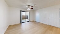 Located at 81955 Hoover Ave in Indio, California, this one-bedroom, one-bathroom unit offers a thoughtfully organized single-floor layout. Light wood-style flooring runs consistently throughout the space, lending a clean, cohesive aesthetic that brightens each room.

The combined kitchen and living area forms the heart of the unit. The galley-style kitchen features white cabinetry lining both walls, ample upper and lower storage, a gas range, refrigerator, and a single-basin sink with recessed lighting overhead. A louvered door at the end of the kitchen conceals additional storage or utility space. The adjacent living area is open and unobstructed, centered around a ceiling fan with light fixture, and opens directly onto a private balcony through a sliding glass door, bringing in natural light and outdoor views.

The bedroom is a generously sized, quiet room with crisp white walls, a textured ceiling, a ceiling fan, a sliding double-door closet, and a window with vertical blinds allowing natural light. The bathroom includes a full tub-shower combination with gold-tone fixtures and clean white surround. Throughout the unit, white baseboards and neutral walls maintain a bright, move-in-ready atmosphere.