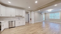 Located at 50 Mount Bethel Rd in Warren, NJ, this thoughtfully designed 2-bedroom, 3-bathroom residence offers a clean, modern aesthetic throughout its single-floor layout. Light oak-toned hardwood flooring flows seamlessly across every room, complemented by neutral warm-gray walls and crisp white trim and crown molding.

The kitchen is a standout feature, showcasing white shaker-style cabinetry with brushed nickel hardware, light quartz countertops, a subway tile backsplash, and a full suite of stainless steel appliances including a gas range, built-in microwave, French door refrigerator, and dishwasher. The kitchen opens directly to a spacious living area, creating a connected, open-concept feel with recessed lighting overhead.

The primary bedroom is generously sized, featuring a wall-mounted split HVAC unit, recessed lighting, a ceiling fixture, crown molding, and a window overlooking greenery. The second bedroom also benefits from natural light through a large window. Both additional rooms offer a clean, versatile canvas.

All three bathrooms are elegantly finished, with the primary bath featuring a double-sink vanity with marble-style quartz countertops, taupe shaker cabinetry, a walk-in glass shower with floor-to-ceiling tile, and terrazzo-style flooring. Additional bathrooms mirror the same refined aesthetic with single-sink vanities and walk-in showers.