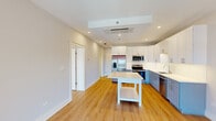 Located at 225 Canal St in Lemont, IL, this well-designed one-bedroom, one-bathroom unit offers a thoughtful layout across a single floor. Light-toned hardwood flooring runs throughout, lending warmth and visual continuity to every room. The open-concept kitchen is a standout feature, showcasing two-tone cabinetry — crisp white uppers paired with soft blue-gray lowers — complemented by a white subway tile backsplash and bright white countertops. Stainless steel appliances, including a French door refrigerator with water dispenser, a range, microwave, and dishwasher, complete the highly functional kitchen. A freestanding island provides additional prep and storage space. The living area is bright and open, with a glass door leading to a private balcony offering outdoor views. The generously sized bedroom is a calm retreat with ample natural light. The bathroom is finished with a bold navy vanity, white countertop, a large mirror, marble-look tile flooring, and a full tub-shower combination. Two well-organized closets with adjustable shelving systems provide excellent storage. Recessed lighting and a cassette-style HVAC unit ensure year-round comfort throughout this clean, modern space.