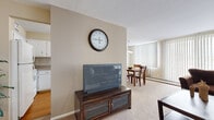 Located at 25151 Brookpark Rd in North Olmsted, Ohio, this single-floor residence offers a well-organized layout designed for comfortable everyday living. The living room is generously sized, featuring plush carpeting, neutral-toned walls, and large windows dressed with vertical blinds that allow ample natural light to fill the space. The open flow connects the living area to a dedicated dining space, illuminated by an elegant multi-globe chandelier and framed by its own window, creating a bright and inviting atmosphere for meals and gatherings. Adjacent to the dining area, the kitchen is efficiently designed with white cabinetry, white appliances including a refrigerator and range, a tile backsplash, and warm hardwood-style flooring, providing a clean and functional cooking environment. The bedroom is a comfortable retreat, highlighted by a bold accent wall, a reach-in closet, carpeted flooring, and a large window with vertical blinds that allow for natural light and privacy. Throughout the residence, the warm, neutral color palette and consistent flooring choices create a cohesive and welcoming ambiance. The thoughtful layout ensures that each area flows naturally into the next, making this North Olmsted residence both practical and inviting.