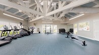 Located at 6158 Beacon Isles Dr in Town N' Country, Florida, this single-story fitness center is a well-appointed exercise facility designed to support a comprehensive workout experience. The space is defined by its striking vaulted ceiling with exposed white-painted wood trusses set against blue-paneled decking, creating a bright and airy atmosphere throughout. Large windows and glass doors line multiple walls, flooding the interior with abundant natural light and offering views of the surrounding greenery and outdoor areas. The flooring throughout is a durable blue-toned carpet tile, practical for a high-use fitness environment. The cardio zone features a row of treadmills and elliptical machines, all equipped with individual screens and positioned to face the windows for an engaging workout experience. The strength training area includes a multi-functional cable machine, a power rack with a bench, and a full dumbbell rack with a wide range of weights, complemented by large wall mirrors that enhance the sense of space. The facility is well-ventilated with ceiling-mounted HVAC systems and wall fans. Access to adjacent areas is provided through glass-paneled French doors, and safety features such as a fire extinguisher and emergency exit signage are clearly visible throughout the space.