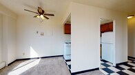 Located at 2233 N Summit Ave in Milwaukee's vibrant East Side neighborhood, this single-floor unit offers a well-organized layout designed for comfortable everyday living. The spacious living area features soft carpeting, a ceiling fan with light fixture, and an open sightline into the kitchen, creating a connected and airy feel. Large windows throughout the unit flood the interior with natural light and frame views of the surrounding Milwaukee cityscape and treetops.

The kitchen is equipped with warm-toned wood cabinetry, white appliances including a range and dishwasher, a stainless steel sink, and a bold black-and-white checkered tile floor that adds a classic, retro character to the space. Upper cabinets provide ample storage along the full length of the kitchen wall.

The bedrooms are carpeted and well-lit, each featuring wide windows with blinds and baseboard heating units positioned beneath the sills. The rooms offer a clean, neutral palette suited for a variety of furnishing styles.

Two bathrooms serve the unit, each with its own distinct character. One features yellow tile accents, a white vanity with under-sink storage, and a large mirror, while the second showcases mint-green tiled walls surrounding a full tub and shower, a light-toned vanity, and tile flooring — both reflecting a mid-century aesthetic throughout.