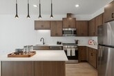 This 640 square foot apartment in Burnsville, MN offers a thoughtful blend of comfort and efficiency. The single-floor layout comprises one bedroom, one bathroom, and an open-concept living area. The primary bedroom, measuring 110 square feet, provides ample space and features a ceiling fan for added comfort. The bathroom boasts a modern design with a wooden vanity, large mirror, and three-light fixture.

The heart of the home is the updated kitchen, which showcases wood cabinetry, stainless steel appliances, and a subway tile backsplash. A central island adds extra prep space and casual dining options. The open floor plan seamlessly connects the kitchen to the living area, creating a sense of spaciousness.

Throughout the apartment, light-colored walls and wood-look flooring contribute to a bright, airy ambiance. Large windows with horizontal blinds allow for natural light and privacy control. The unit also includes a closet with wire shelving for organized storage.

Recessed lighting and modern fixtures provide ample illumination throughout the space. The apartment's efficient design maximizes functionality in every square foot, making it an ideal choice for those seeking a comfortable, low-maintenance living space in a convenient Burnsville location.