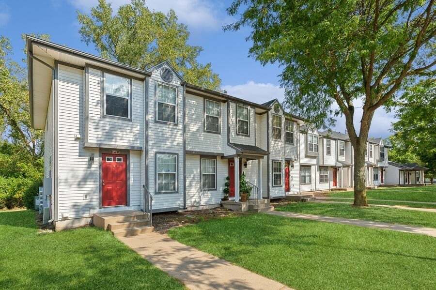 Una hilera de casas adosadas con una puerta roja. - Mason Street Townhomes